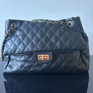 Stylish black shoulder bag with gold and leather straps. Medium size.